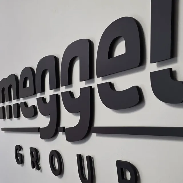 Lettere nere in rilievo meggel GROUP sulla parete di un ufficio