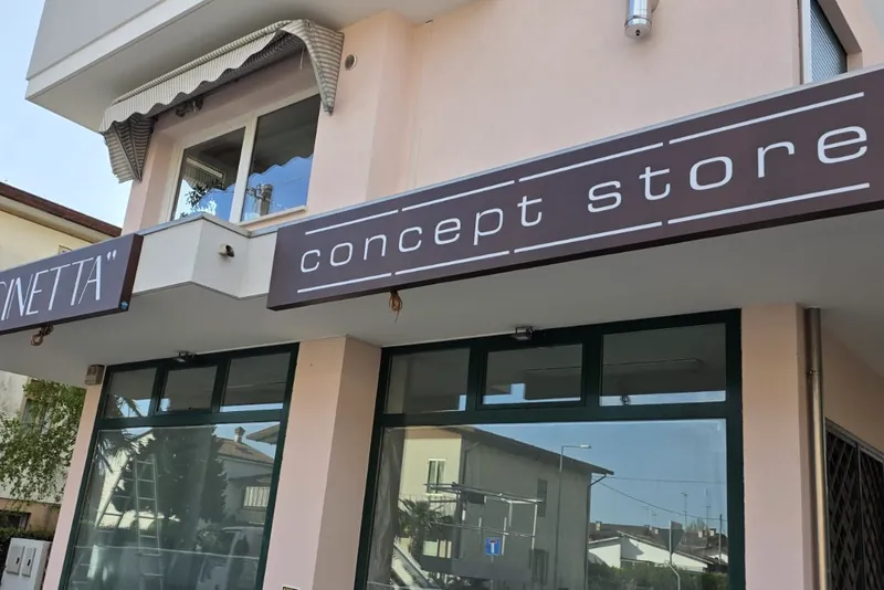 Insegne IN CUCINETTA e concept store su una facciata