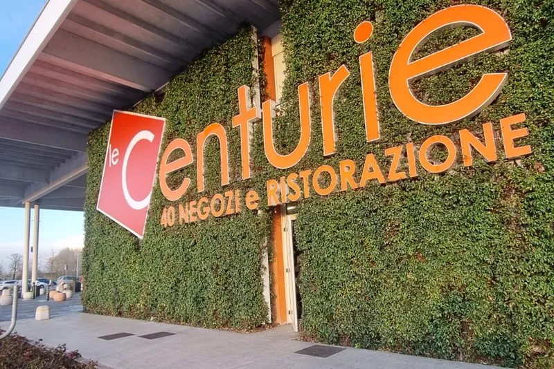 Lettere luminose le Centurie sulla parete verde del centro commerciale