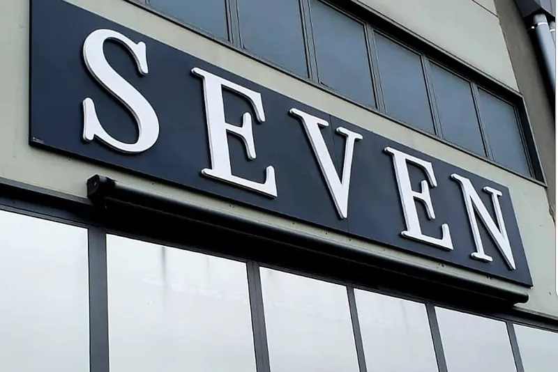 Lettere SEVEN in rilievo su una fascia nera in facciata